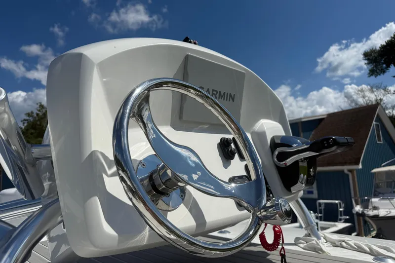 Slide: The Image of Steering wheel of 2026 Pair Customs 27 Center Console boat under blue sky. - 11