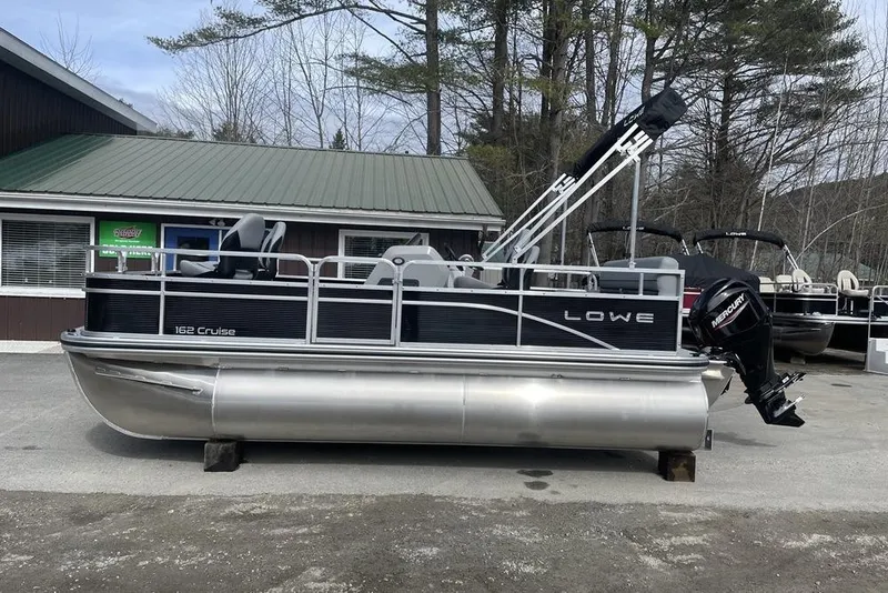Slide: The Image of 2024 Lowe Ultra 162 Fish & Cruise pontoon boat parked outdoors. - 1