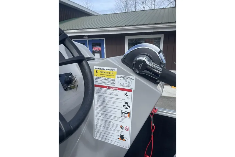 Slide: The Image of 2024 Lowe Ultra 162 Fish & Cruise boat console with capacity and safety labels. - 14