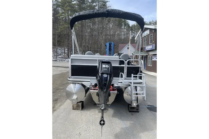 Slide: The Image of 2024 Lowe Ultra 162 Fish & Cruise pontoon boat with outboard motor, parked outdoors. - 4