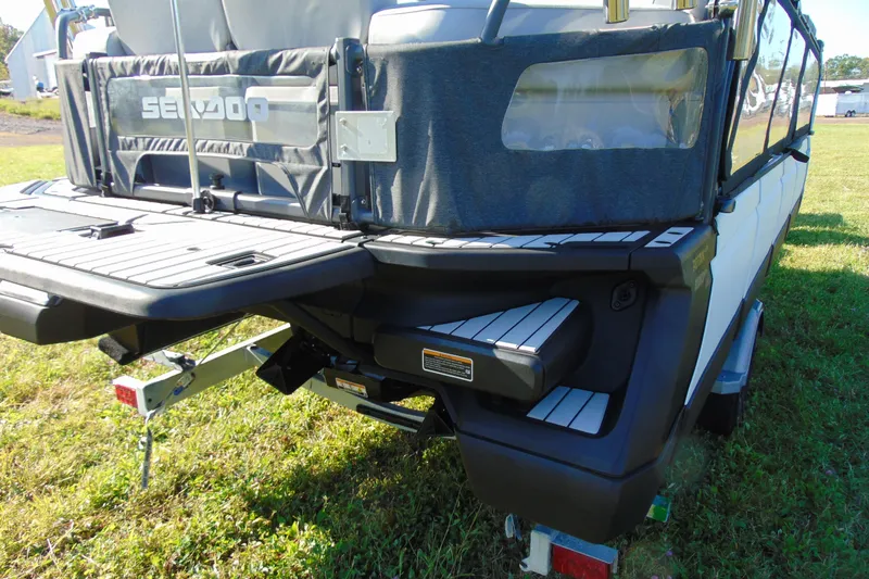 Slide: The Image of 2023 Sea-Doo Switch Cruise 21 rear view on grass, showcasing deck and trailer. - 6