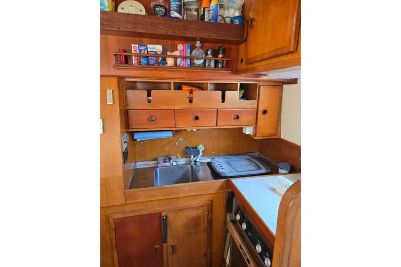 Slide: The Image of 1987 Transpacific Marine Eagle 32 boat kitchen with wooden cabinets and sink. - 12