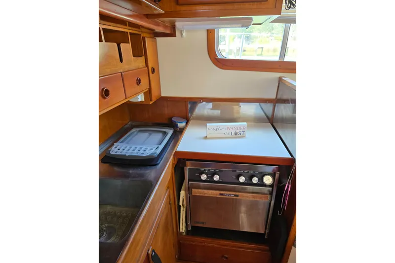 Slide: The Image of 1987 Transpacific Marine Eagle 32 galley with stove, sink, and wooden cabinetry. - 14