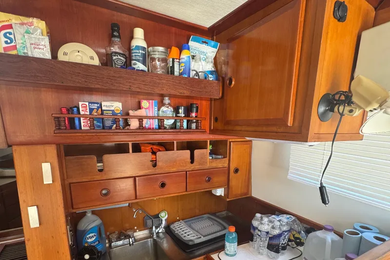 Slide: The Image of 1987 Transpacific Marine Eagle 32 galley with wooden cabinets and various kitchen supplies. - 15