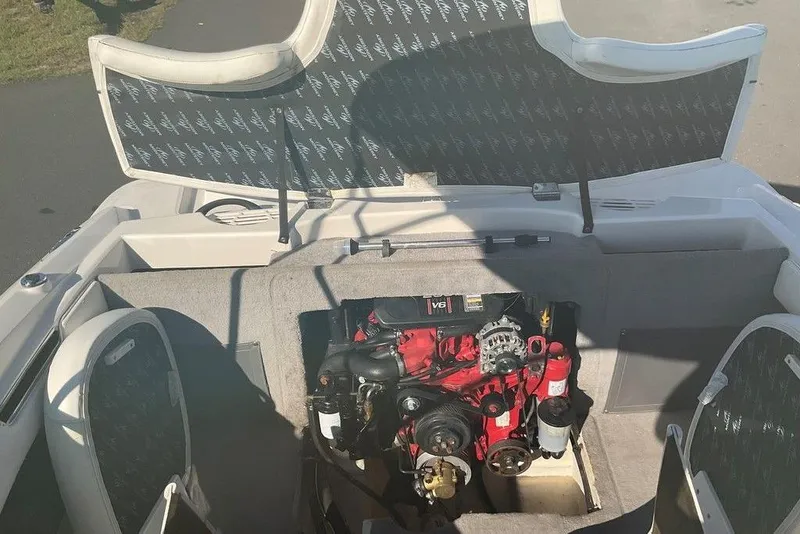 Slide: The Image of 2009 Monterey 180 FS boat engine compartment with V6 engine, open seating, and carpeted interior. - 11