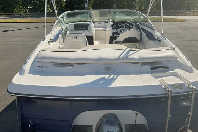 Slide: The Image of 2009 Monterey 180 FS boat interior with steering wheel and seating, parked outdoors. - 3