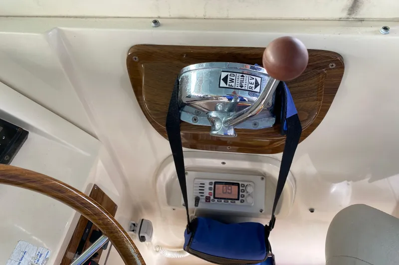 Slide: The Image of 2003 Mainship Pilot 30-II Sedan helm with white cushioned seat and control panel. - 12