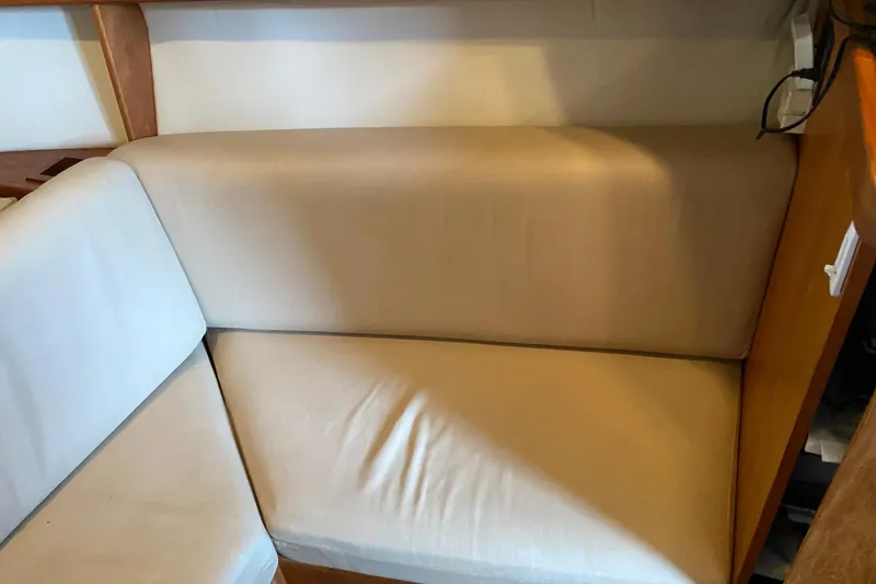 Slide: The Image of 2003 Mainship Pilot 30-II Sedan interior with wood paneling and cushioned seating. - 26