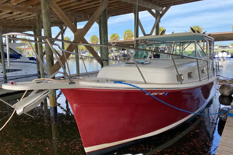 Slide: The Image of 2003 Mainship Pilot 30-II Sedan boat docked under a wooden shelter. - 36