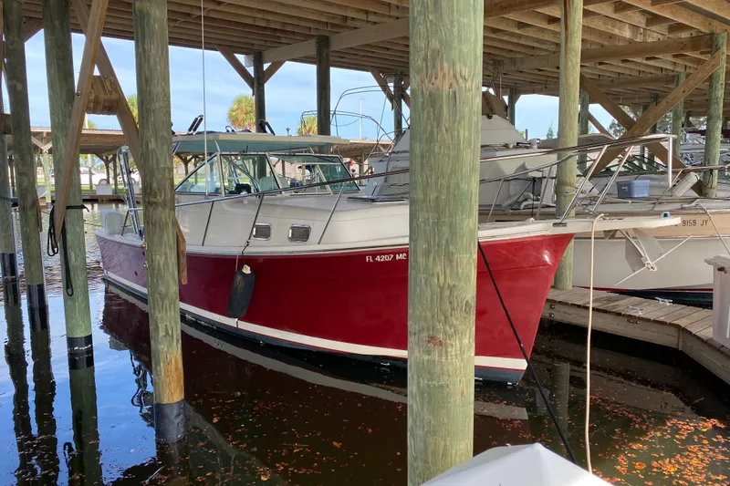 Slide: The Image of 2003 Mainship Pilot 30-II Sedan boat docked under wooden shelter. - 37