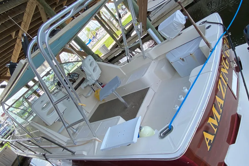 Slide: The Image of 2003 Mainship Pilot 30-II Sedan boat docked, featuring white seating and sleek design. - 5