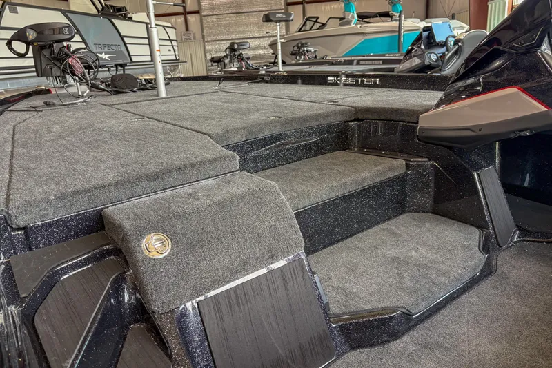 Slide: The Image of 2026 Skeeter ZXE20 boat interior with carpeted steps and deck in a showroom. - 14