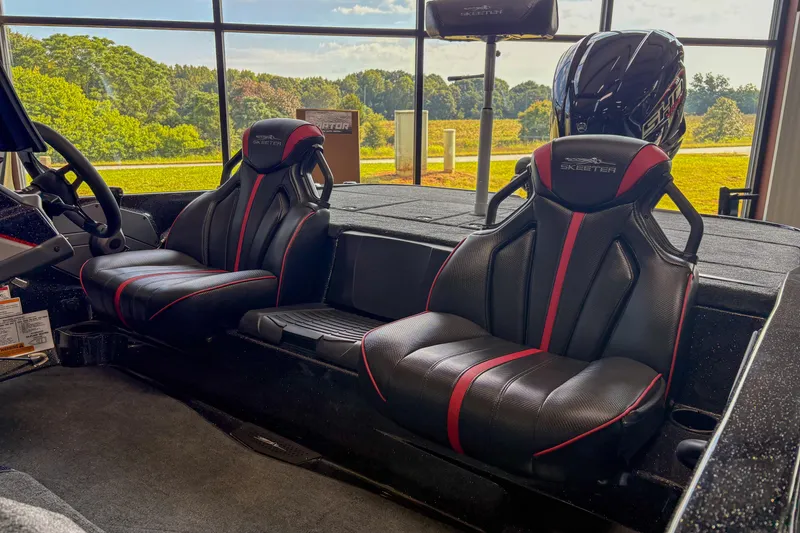 Slide: The Image of 2026 Skeeter ZXE20 boat interior with black and red seats, steering wheel, and outdoor view. - 15
