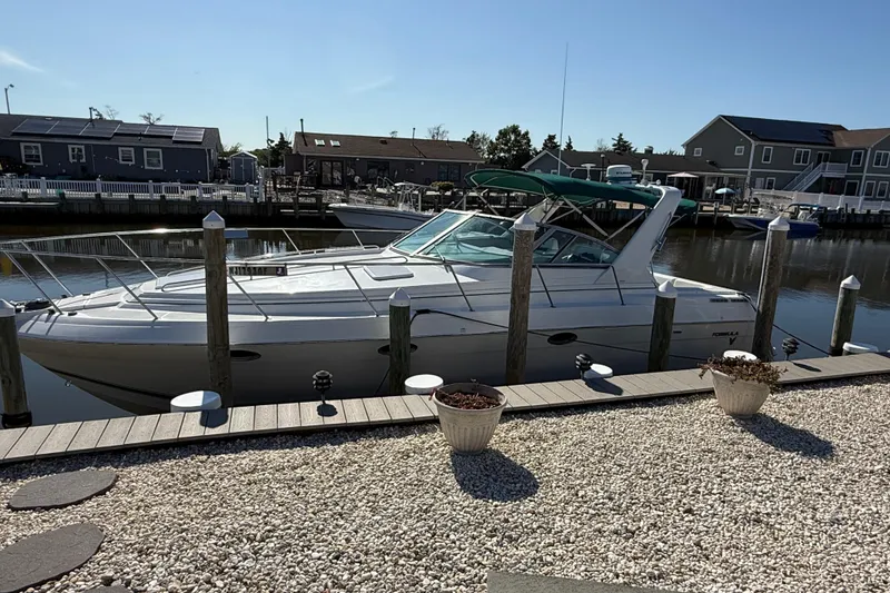 The Image of 1998 Formula 34 Performance Cruiser docked at a marina, surrounded by waterfront homes. - 0