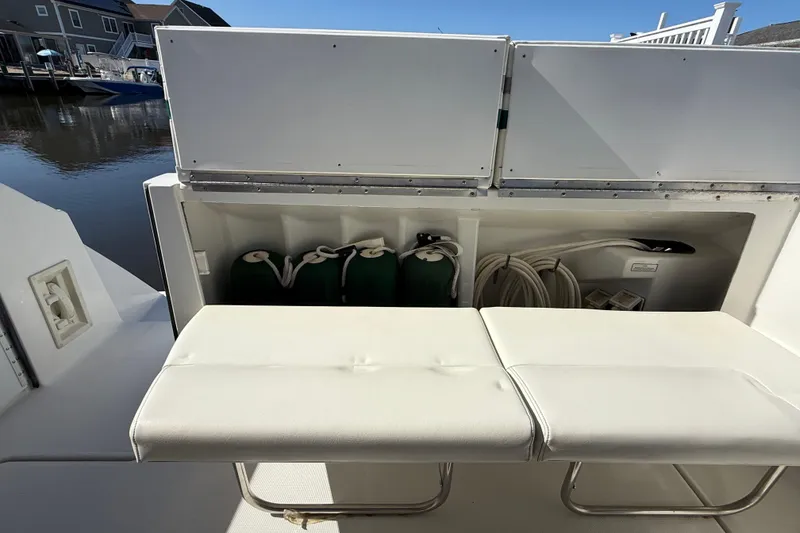 Slide: The Image of 1998 Formula 34 Performance Cruiser storage area with white seating and dock view. - 12