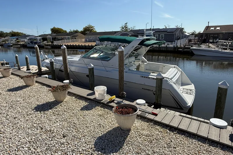 Slide: The Image of 1998 Formula 34 Performance Cruiser docked by a waterfront home. - 2