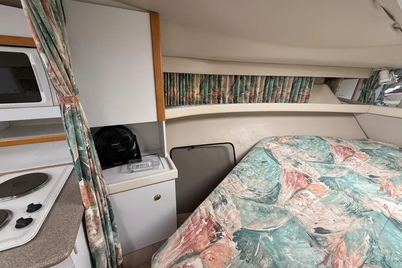 Slide: The Image of 1998 Formula 34 Performance Cruiser interior with bed, kitchenette, and patterned curtains. - 26