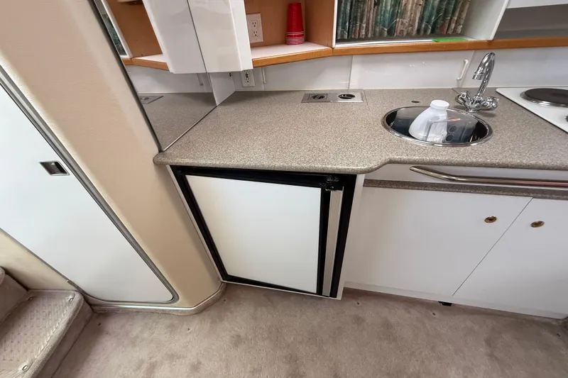 Slide: The Image of 1998 Formula 34 Performance Cruiser kitchen with sink, countertop, and mini fridge. - 31