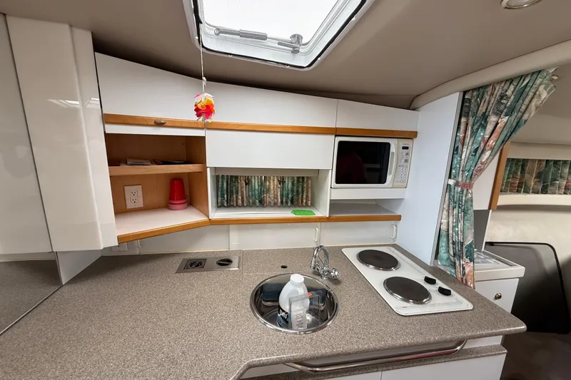 Slide: The Image of 1998 Formula 34 Performance Cruiser kitchen with stove, sink, microwave, and storage cabinets. - 33