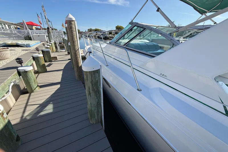Slide: The Image of 1998 Formula 34 Performance Cruiser docked at a marina under clear blue skies. - 5