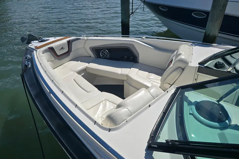 Slide: The Image of 2014 Monterey 288 Super Sport boat with white leather seating, docked on calm water. - 14