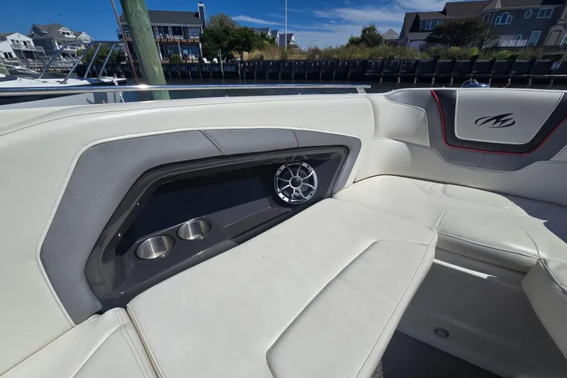 Slide: The Image of 2014 Monterey 288 Super Sport boat interior with speaker and cup holders, docked near waterfront homes. - 20