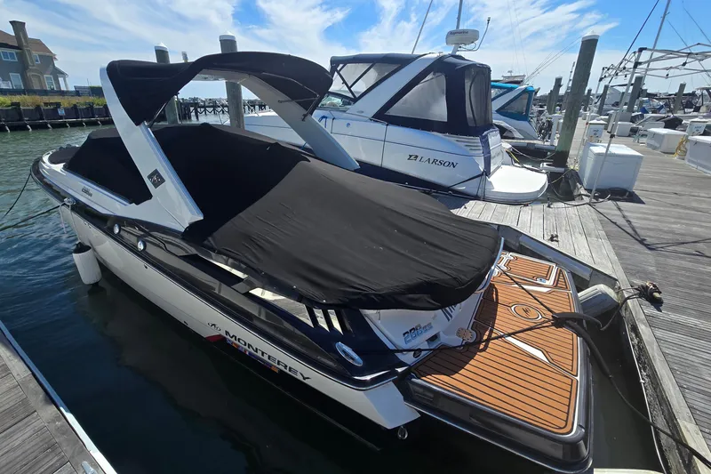 Slide: The Image of 2014 Monterey 288 Super Sport boat docked with black cover, sunny day, marina setting. - 3