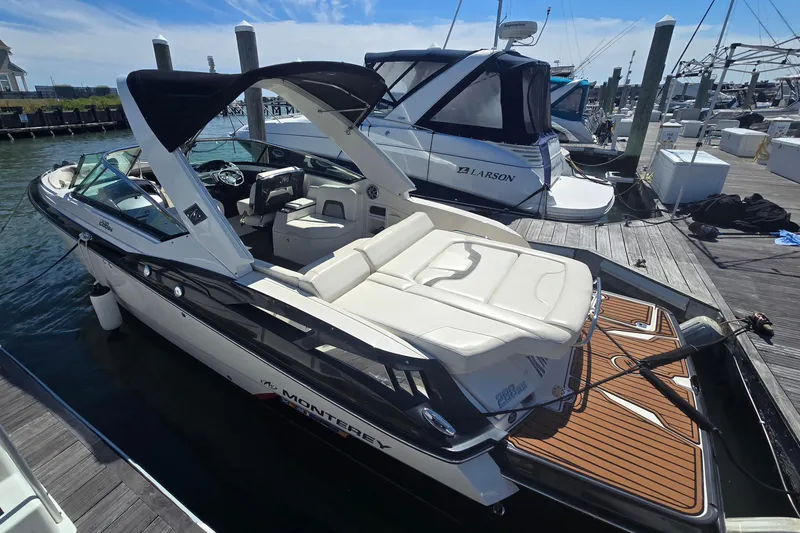 Slide: The Image of 2014 Monterey 288 Super Sport boat docked at marina, featuring sleek design and spacious seating. - 7