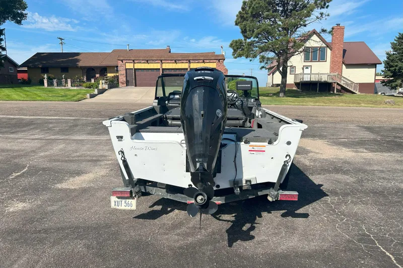 Slide: The Image of 2023 Lund 1775 Adventure Sport boat with outboard motor, parked in residential driveway. - 8