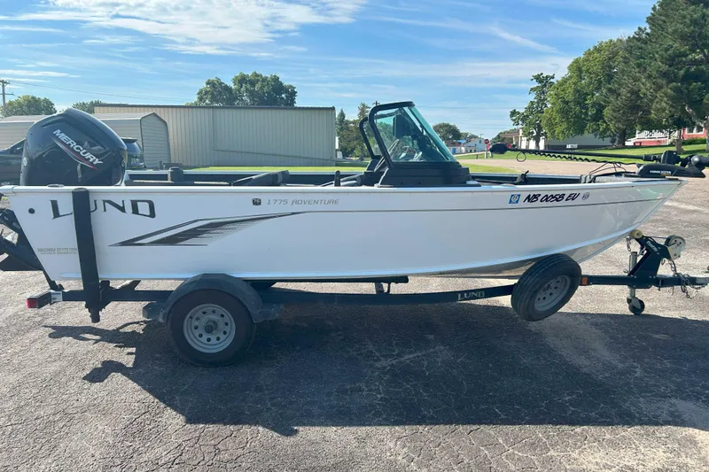 Slide: The Image of 2023 Lund 1775 Adventure Sport boat on trailer, parked outdoors under clear sky. - 9