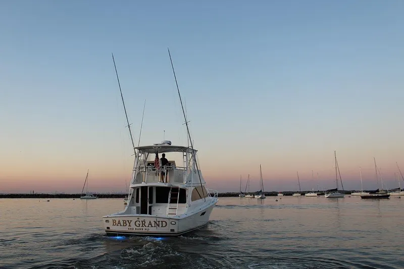 Slide: The Image of 2006 Egg Harbor 43 Sport Yacht cruising at sunset with sailboats in the background. - 25