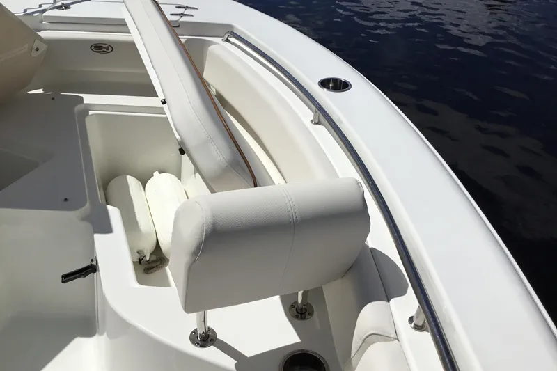 Slide: The Image of 2020 Sea Hunt Ultra 225 boat interior with white seating and storage compartment. - 17