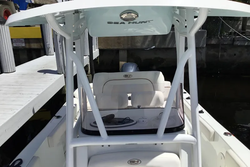 Slide: The Image of 2020 Sea Hunt Ultra 225 boat docked, featuring a sleek white design and spacious seating. - 21