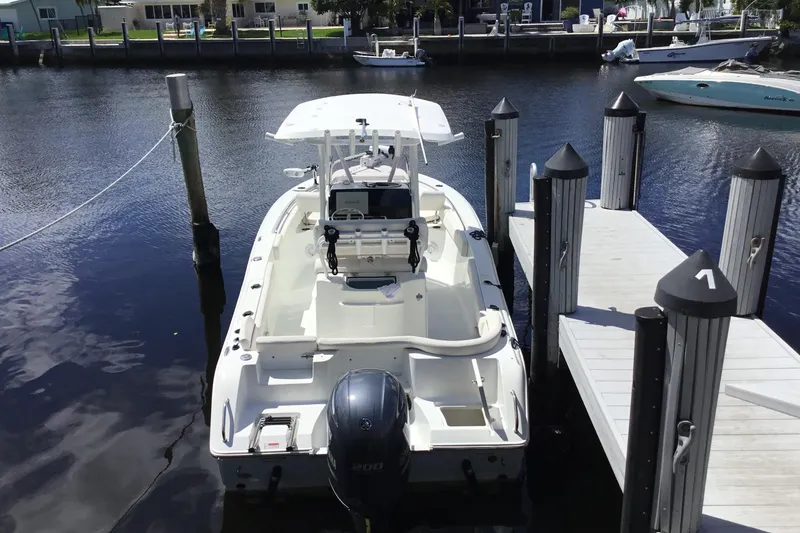 Slide: The Image of 2020 Sea Hunt Ultra 225 boat docked at marina, rear view. - 48