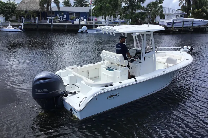 Slide: The Image of 2020 Sea Hunt Ultra 225 boat with Yamaha engine on a calm waterway. - 7