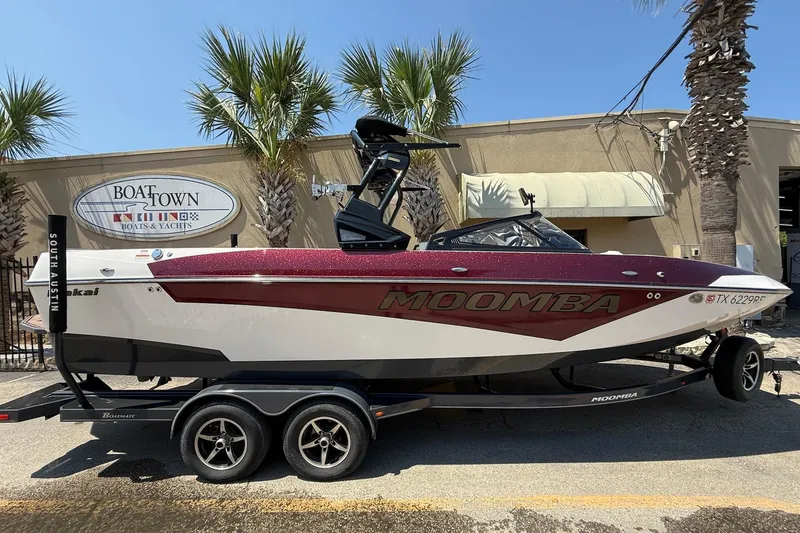 The Image of 2019 Moomba Makai boat on trailer at Boat Town, South Austin, with palm trees. - 1