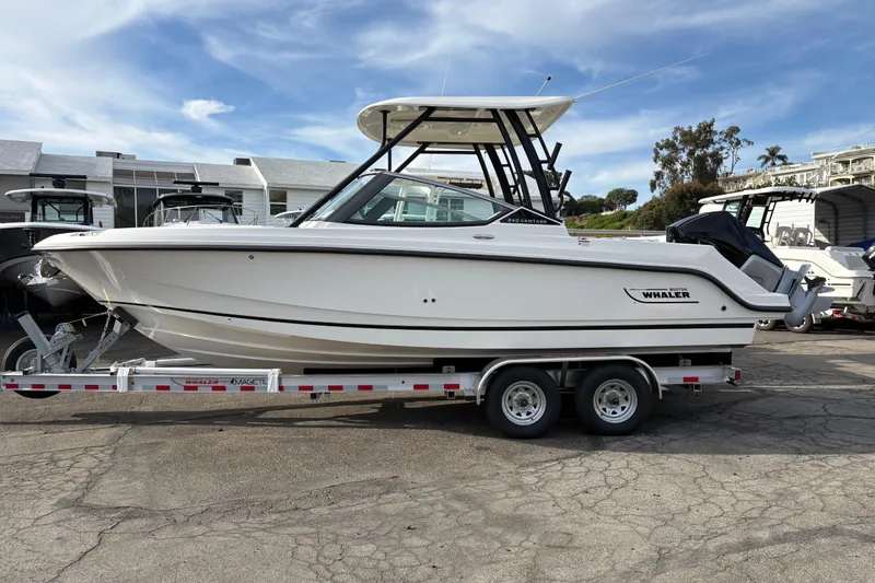 The Image of 2026 Boston Whaler 240 Vantage boat on trailer, parked outdoors under a clear sky. - 0