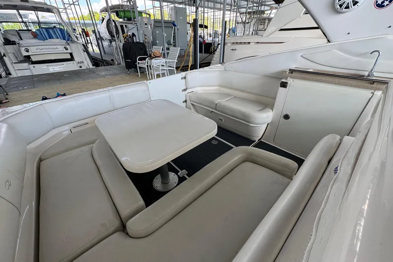 Slide: The Image of 2004 Regal Commodore 3260 boat interior with seating and table in a marina setting. - 19