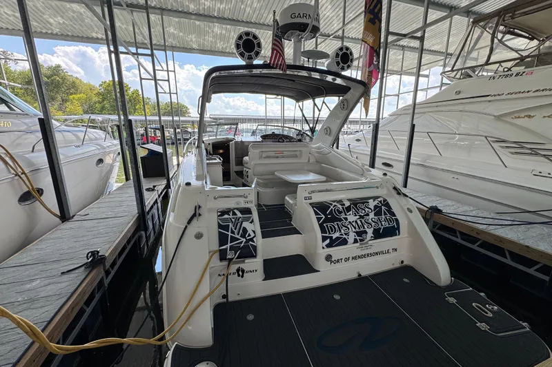 Slide: The Image of 2004 Regal Commodore 3260 boat docked at marina, rear view with "Class Dismissed" sign. - 6