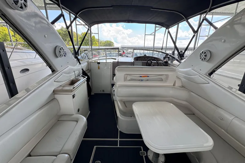 Slide: The Image of 2004 Regal Commodore 3260 boat interior with seating, table, and helm under canopy. - 7