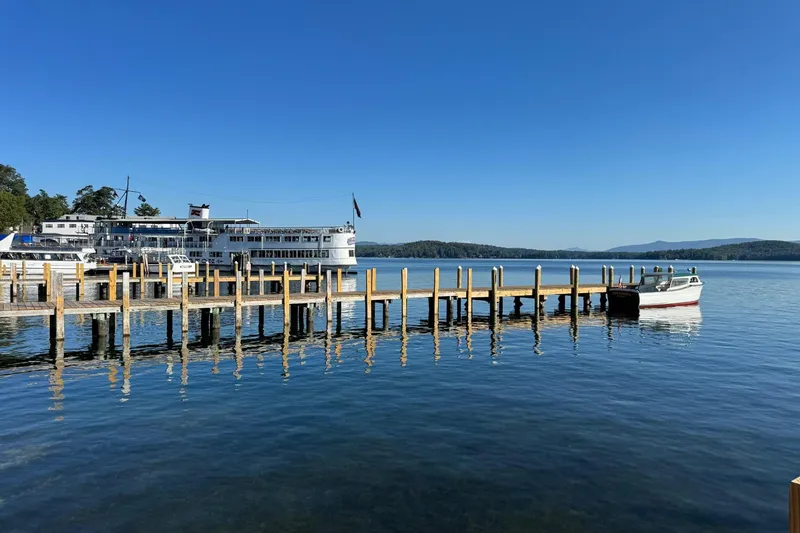 Slide: The Image of 1940 Chris-Craft Launch 25 docked on serene lake with clear blue sky. - 1