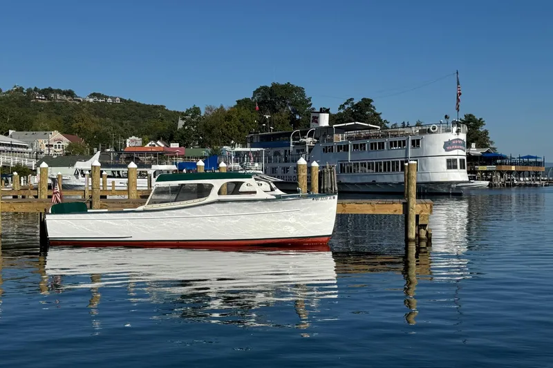 Slide: The Image of 1940 Chris-Craft Launch 25 boat docked in scenic marina with clear blue sky. - 10