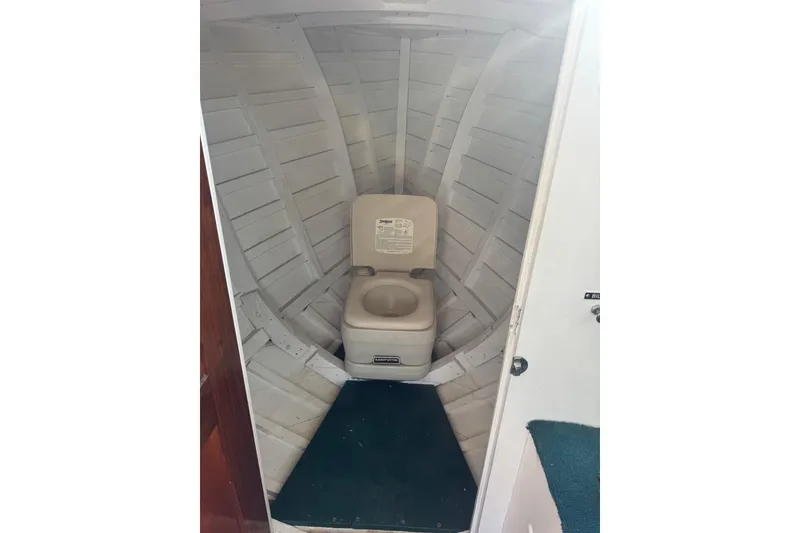 Slide: The Image of 1940 Chris-Craft Launch 25 boat interior with portable toilet in wooden cabin. - 12