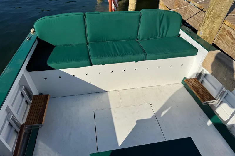 Slide: The Image of 1940 Chris-Craft Launch 25 boat interior with green cushioned seating and wooden accents. - 17
