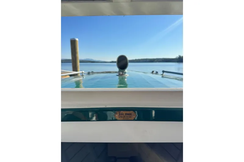 Slide: The Image of 1940 Chris-Craft Launch 25 boat on calm water, clear sky, dock in background. - 19