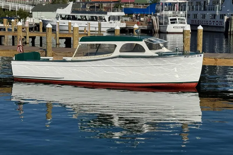 Slide: The Image of 1940 Chris-Craft Launch 25 boat docked on calm water, reflecting its classic design. - 20