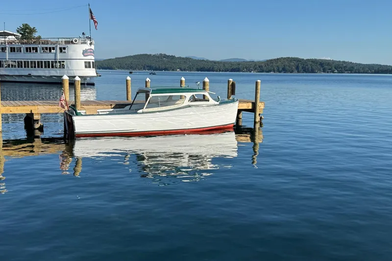 Slide: The Image of 1940 Chris-Craft Launch 25 boat docked on a serene lake with scenic background. - 7