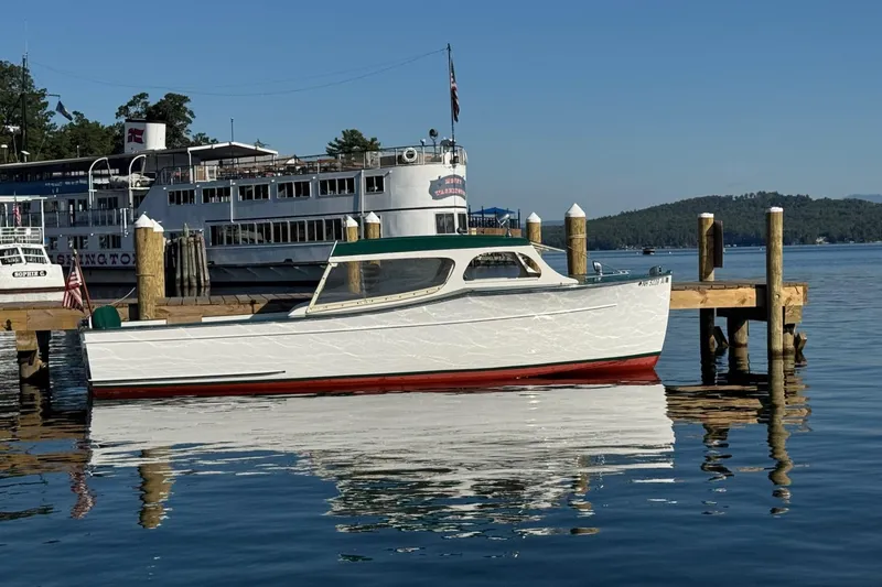 Slide: The Image of 1940 Chris-Craft Launch 25 boat docked on calm lake with scenic background. - 8