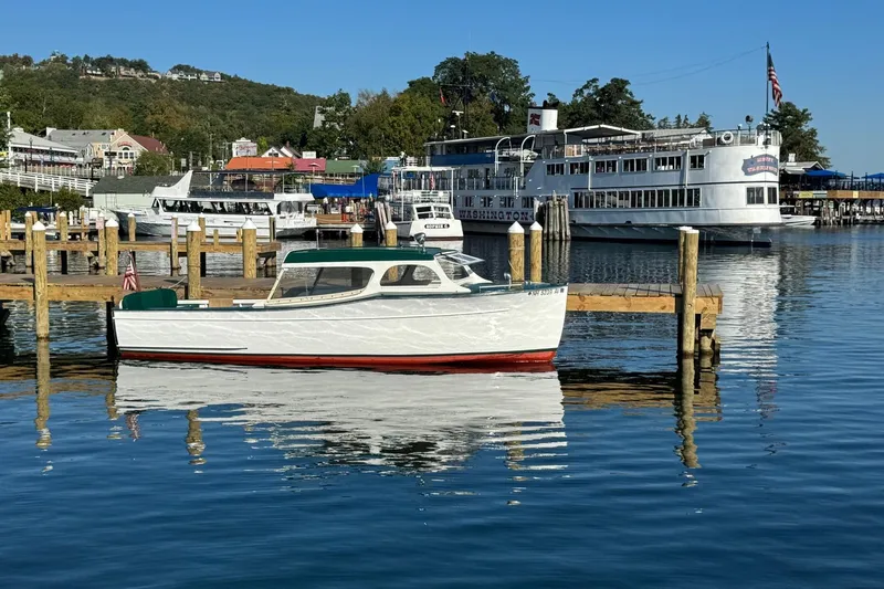 Slide: The Image of 1940 Chris-Craft Launch 25 boat docked in scenic marina with larger vessels. - 9