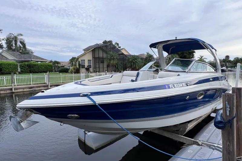 Slide: The Image of 2022 Crownline 290 XSS boat docked on a serene waterfront. - 10